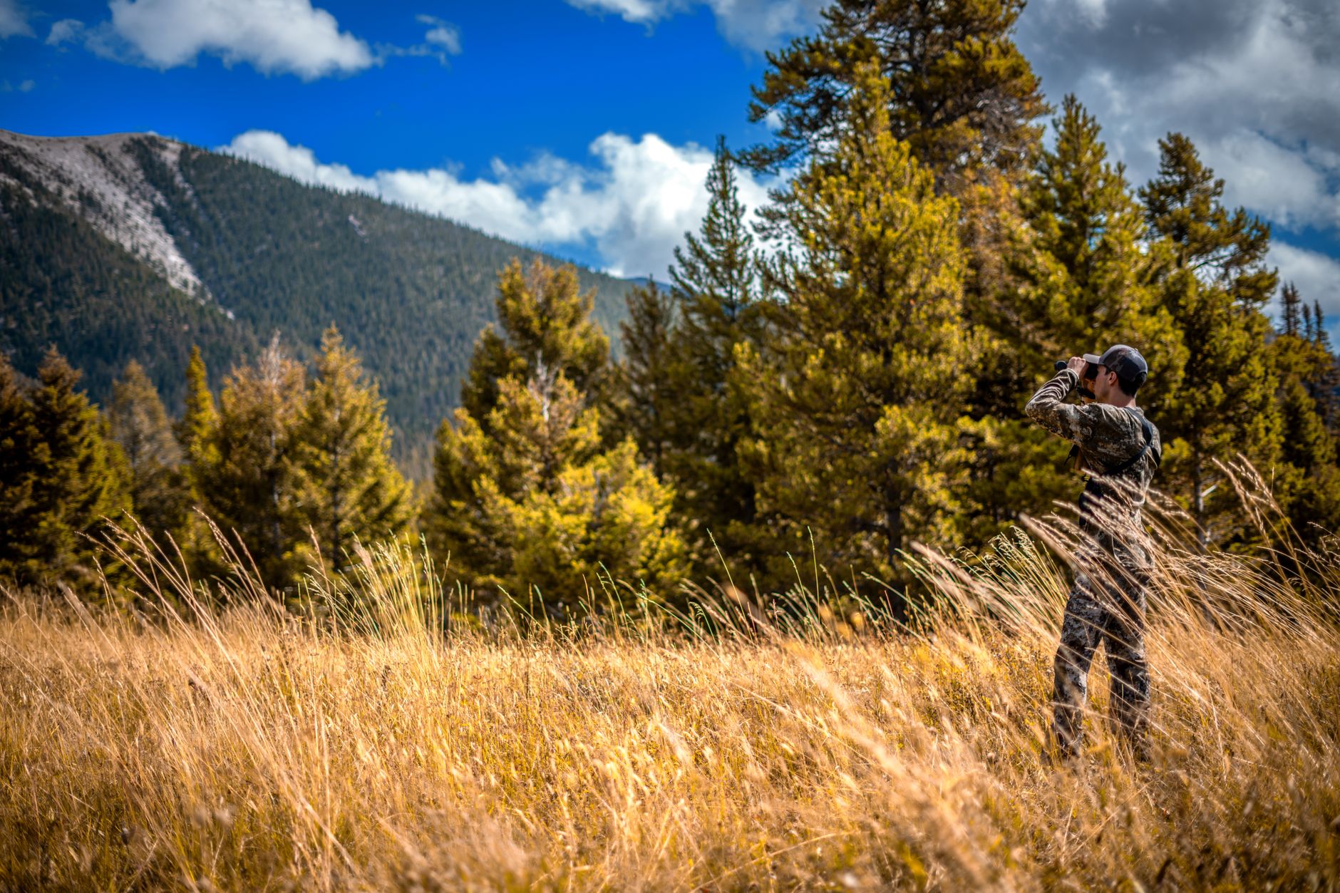 Hunter with field glasses in mountain terrain
